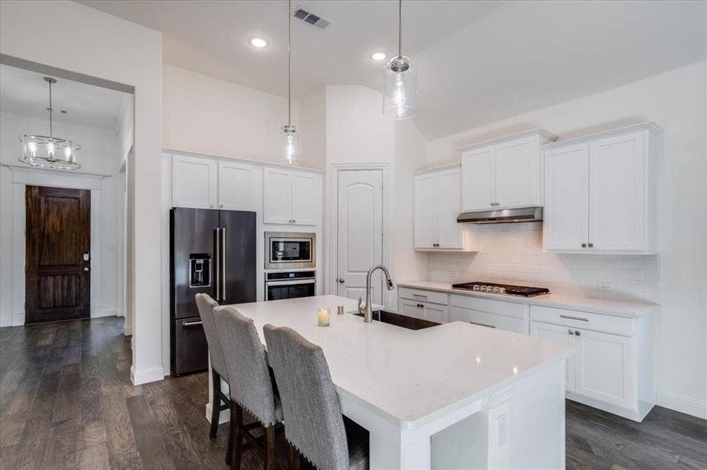 Custom painted cabinetry with shaker style doors and stainless hardware.