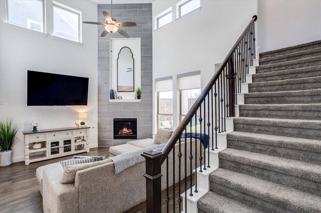 Carpeted staircase with iron spindles.