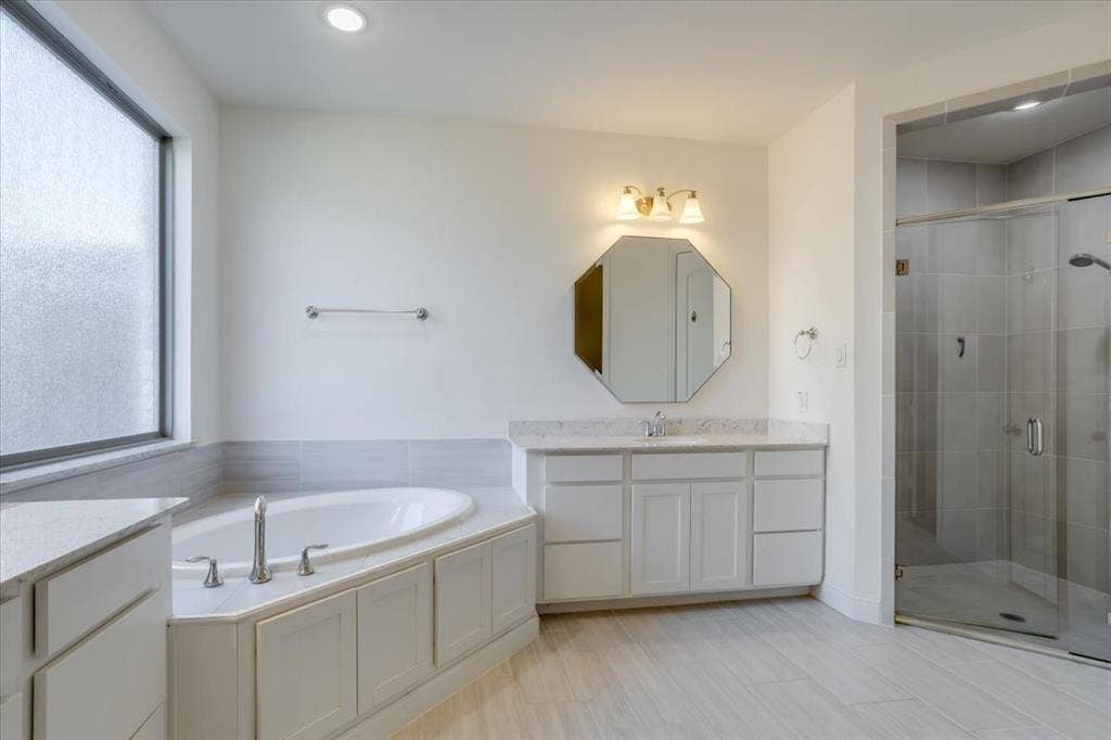 Primary Bathrooms- clean and classic from the rectangular tiled floors to the painted cabinetry and quartz countertops.