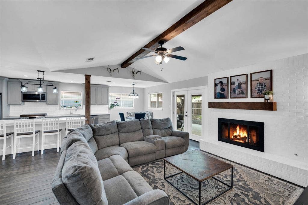 106 Hillcrest Drive, Midlothian, TX 76065 Living area featuring a ceiling fan, dark wood-type flooring, beamed ceiling, a fireplace, and french doors