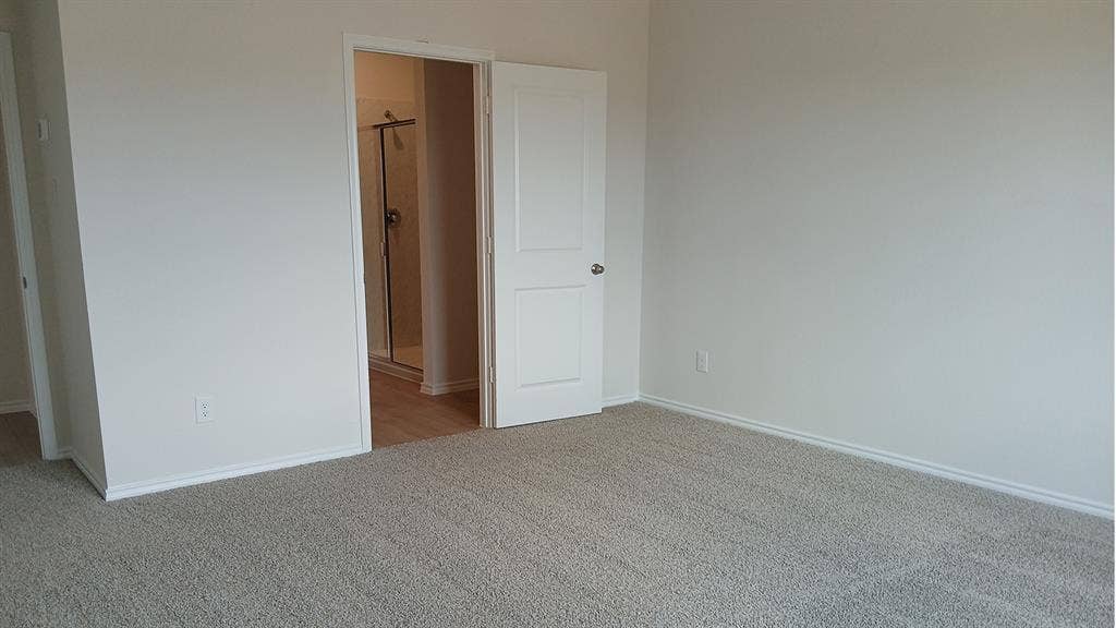 223 Whispering Pine Drive, Royse City, TX 75189 Carpeted room with white painted walls and trim, featuring a white paneled door