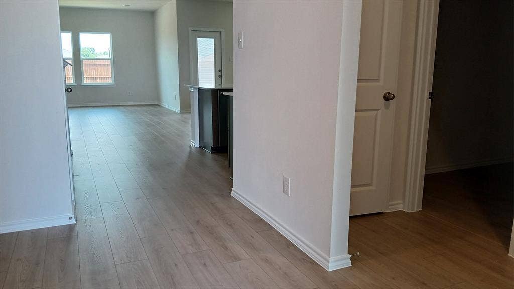 223 Whispering Pine Drive, Royse City, TX 75189 Light wood-finish flooring throughout, complemented by white baseboards and neutral wall tones