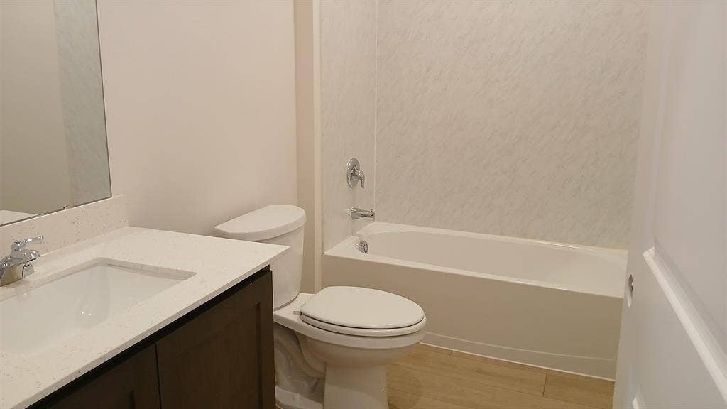 223 Whispering Pine Drive, Royse City, TX 75189 Bathroom featuring a white bathtub, toilet, and vanity with a light-colored countertop