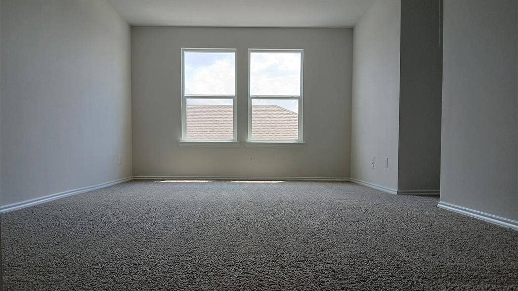 223 Whispering Pine Drive, Royse City, TX 75189 Spacious room featuring neutral carpeting, light-toned walls, and white baseboards
