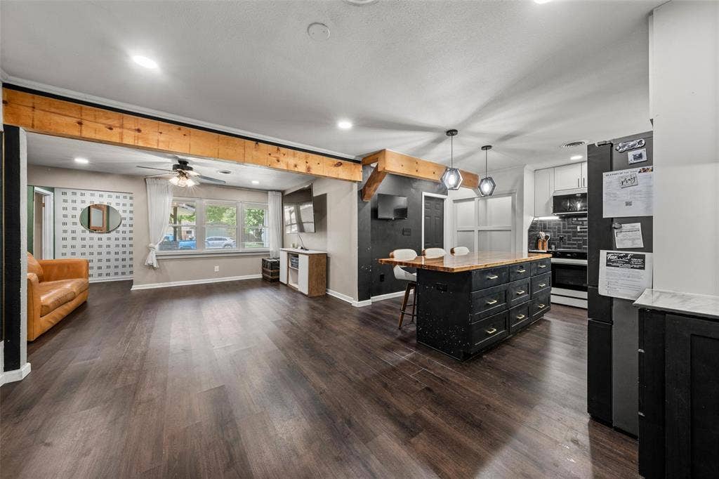 1207 Pembrook Drive, Waco, TX 76710 Dual tone kitchen featuring open floor plan, decorative light fixtures, a kitchen breakfast bar, freestanding refrigerator, and two tone cabinets