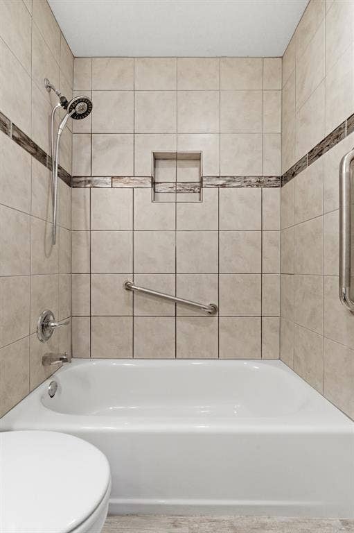 Full bathroom featuring toilet and shower / washtub combination