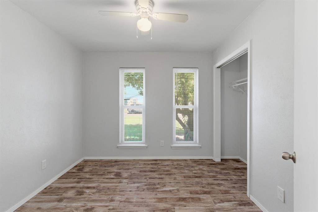 Unfurnished bedroom featuring light wood-style floors, a closet, and ceiling fan