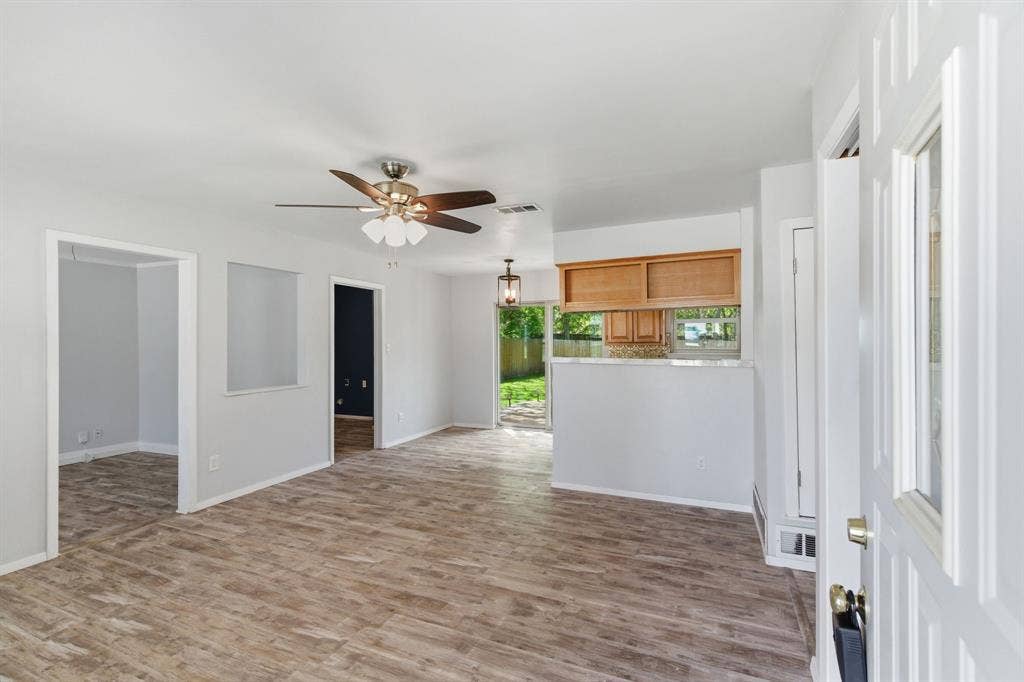 Unfurnished living room featuring light wood-type flooring and ceiling fan