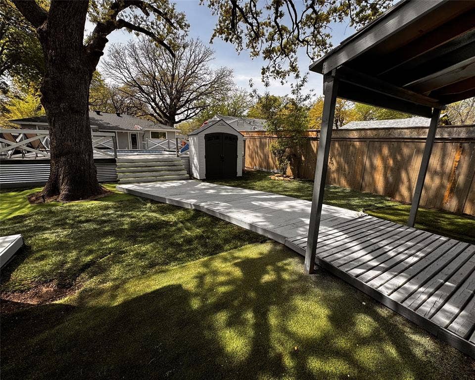 3020 Delaware Trail, Lake Worth, TX 76135 View of yard featuring an outbuilding, a fenced backyard, a wooden deck, and a shed