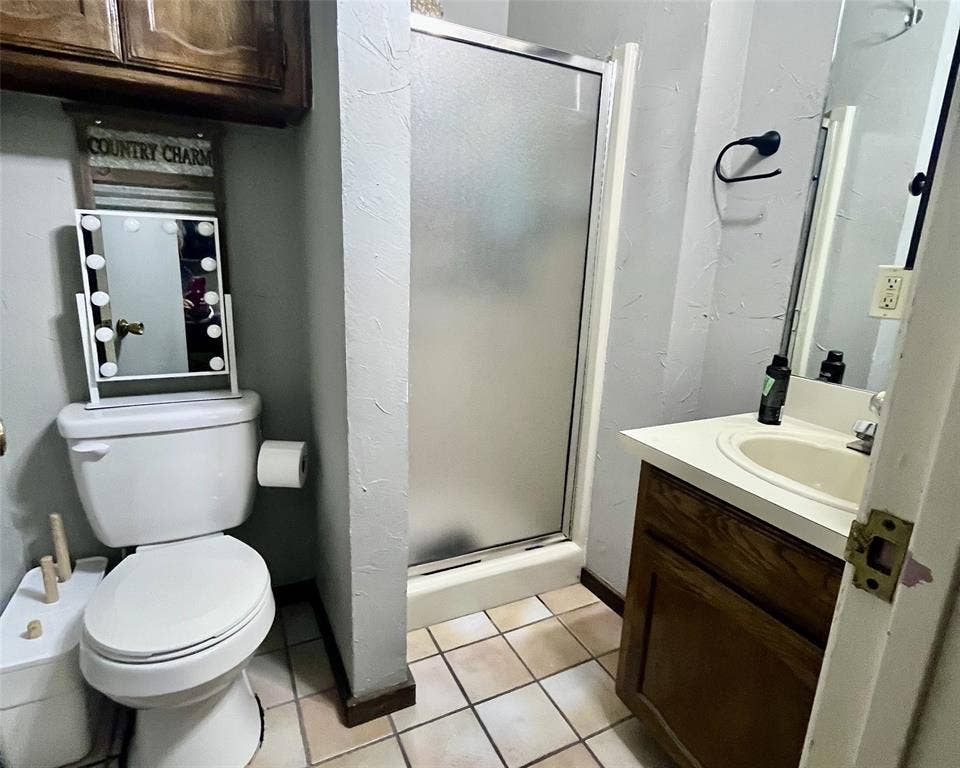 3020 Delaware Trail, Lake Worth, TX 76135 Bathroom with vanity, toilet, tile patterned floors, and a shower stall