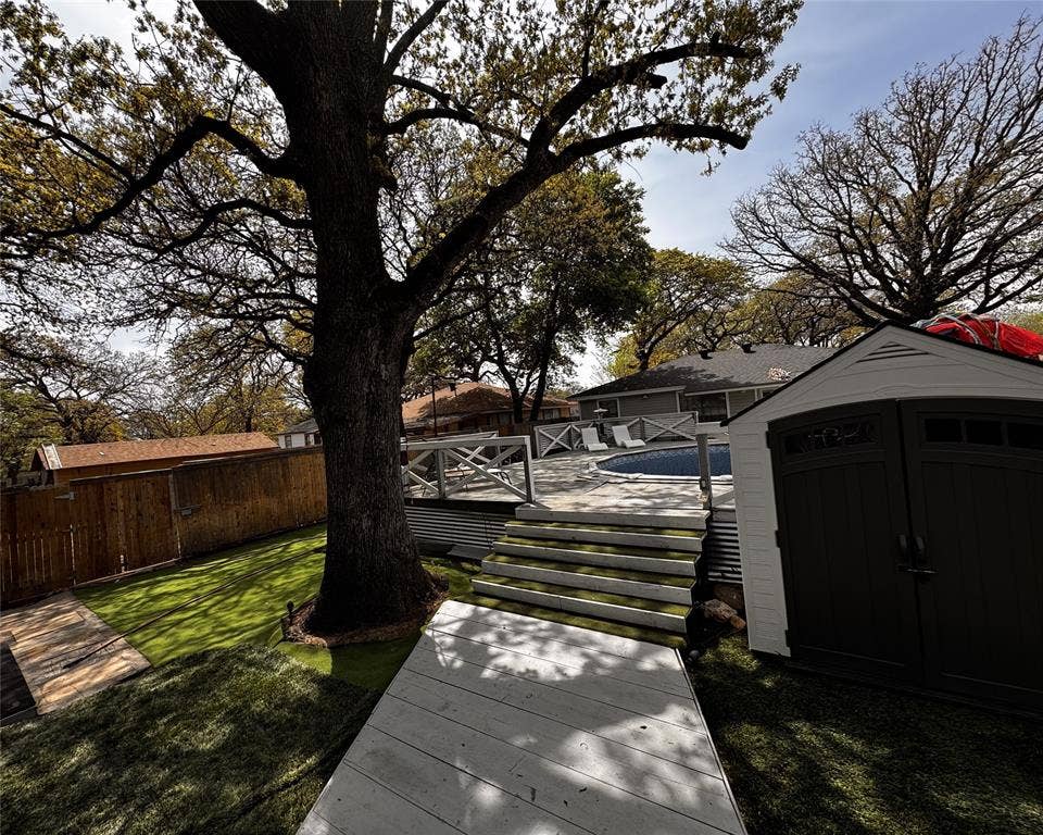 3020 Delaware Trail, Lake Worth, TX 76135 View of yard with an outdoor structure, a storage unit, fence, and a wooden deck