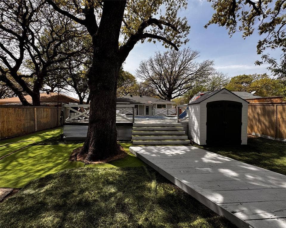 3020 Delaware Trail, Lake Worth, TX 76135 View of yard with an outdoor structure, a fenced backyard, a storage unit, and a deck