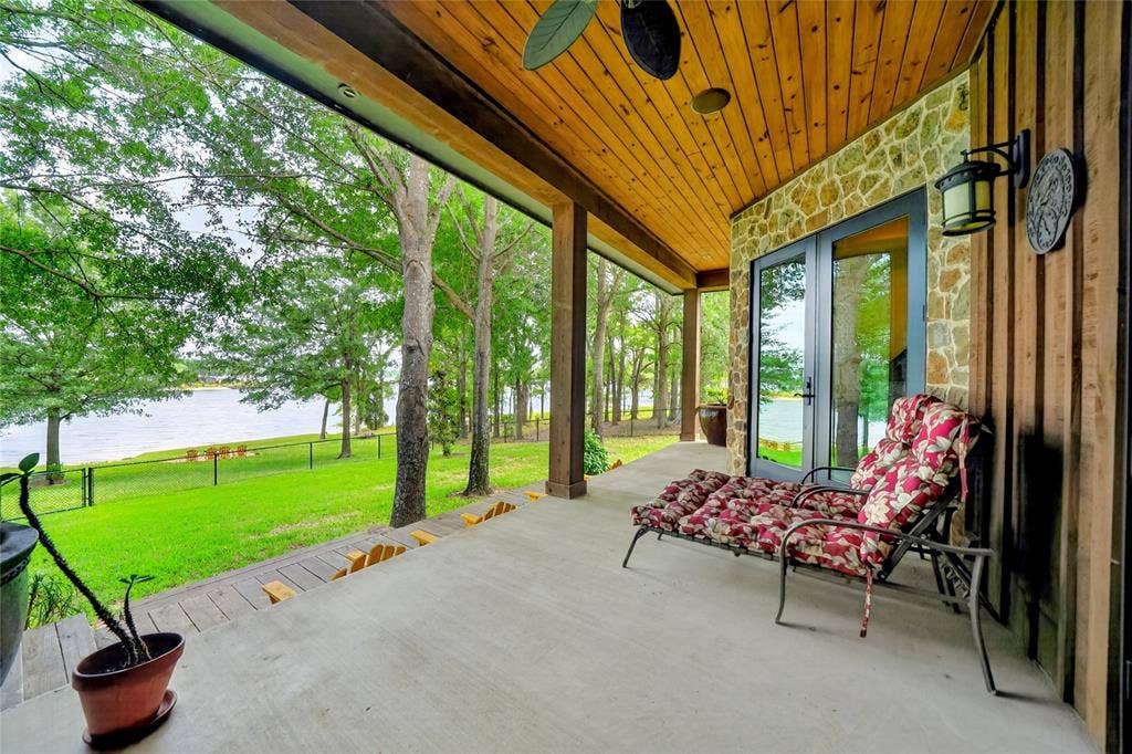 15491 Presidio Circle, Caney City, TX 75148 Covered patio with concrete flooring, wood-paneled ceiling, stone accents, and a water view