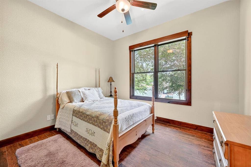 15491 Presidio Circle, Caney City, TX 75148 Room featuring wood-finish flooring, a ceiling fan with light fixture, and a large window with dark wood trim