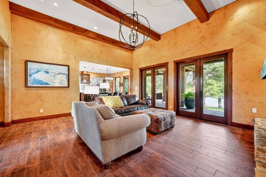 15491 Presidio Circle, Caney City, TX 75148 Spacious living area featuring high vaulted ceilings with exposed wood beams, wood-finish flooring, and plaster-finish walls