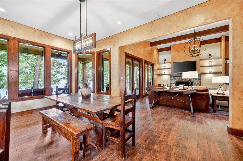 15491 Presidio Circle, Caney City, TX 75148 Open-concept living space featuring wood-finish flooring, a contemporary linear chandelier, and expansive windows