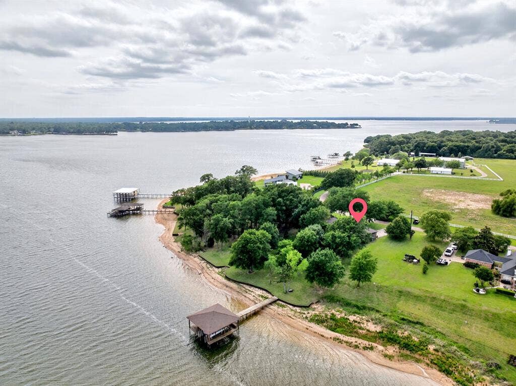 15491 Presidio Circle, Caney City, TX 75148 Waterfront property featuring extensive shoreline, mature trees, a private boat dock with covered slip, and a large grassy lot