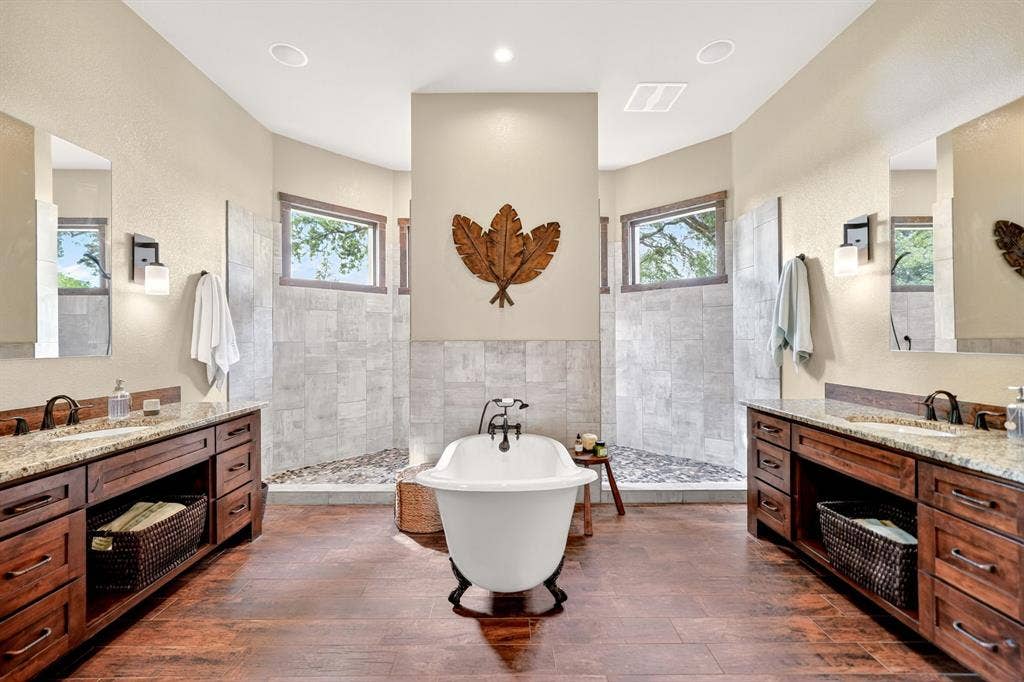 15491 Presidio Circle, Caney City, TX 75148 Freestanding clawfoot bathtub centered in a spacious bathroom featuring wood-finish flooring
