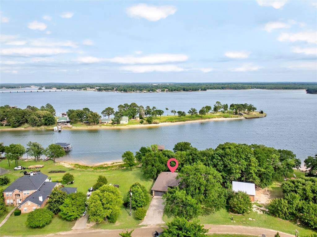 15491 Presidio Circle, Caney City, TX 75148 Waterfront property featuring a private boat dock, sandy beach shoreline, and mature trees