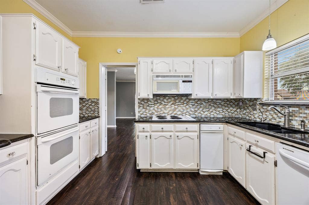 9209 Chimneywood Drive, Rowlett, TX 75089 Kitchen with granite countertops, double oven and electric cooktop.