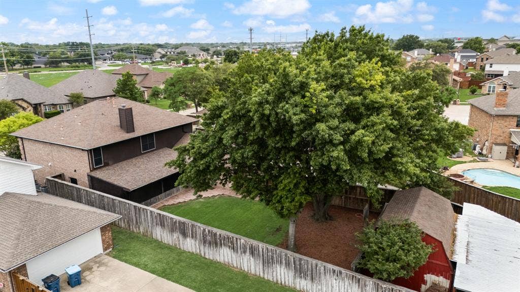 9209 Chimneywood Drive, Rowlett, TX 75089 Backyard view showing the two story workshop and carport cover.