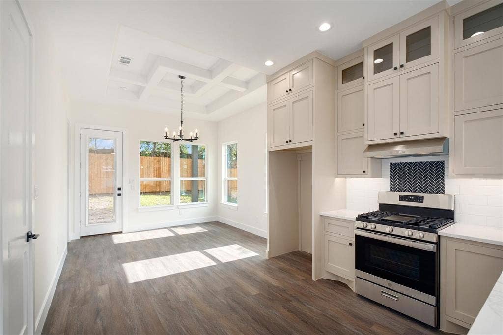 802.5 N Needmore Street, Athens, TX 75751 Kitchen with gas range, coffered ceiling, hanging lights, dark wood-type flooring, and decorative backsplash