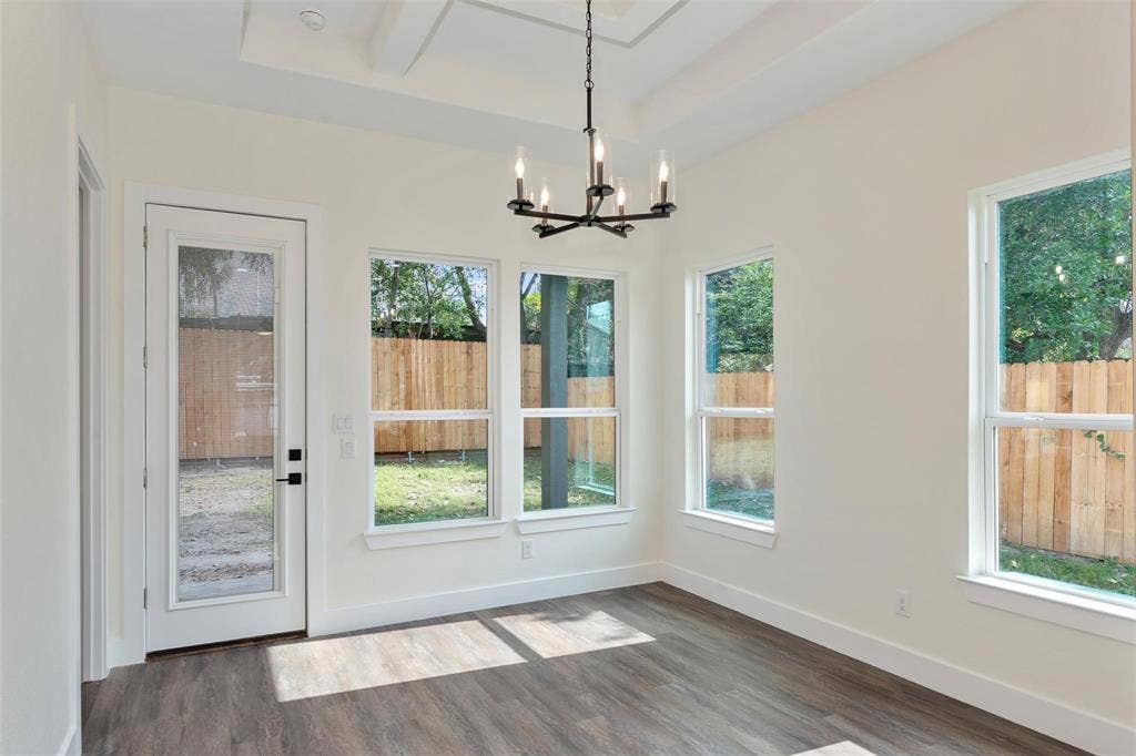 802.5 N Needmore Street, Athens, TX 75751 Unfurnished dining area featuring dark wood-style flooring, a chandelier, and a tray ceiling