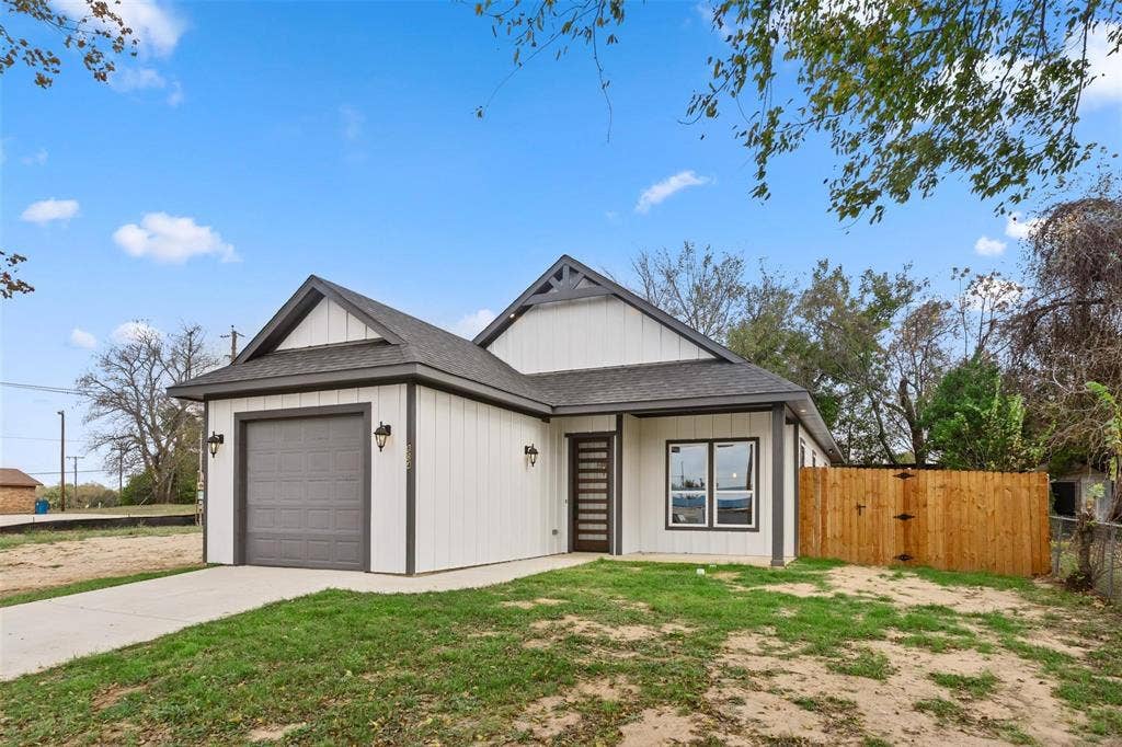 802.5 N Needmore Street, Athens, TX 75751 View of front of home with a shingled roof, an attached garage, a gate, and concrete driveway