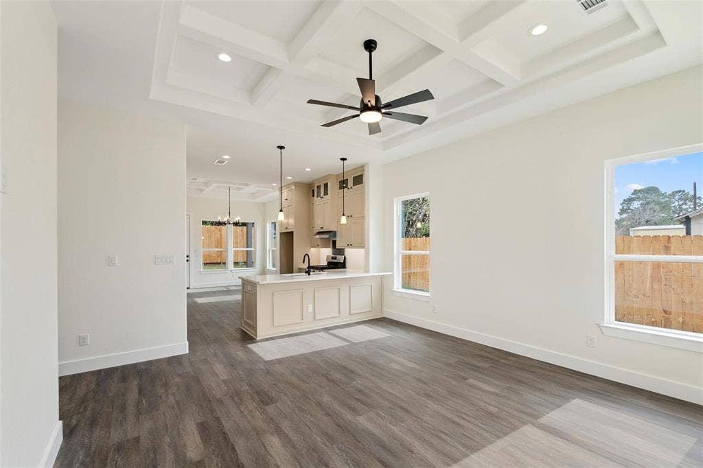 802.5 N Needmore Street, Athens, TX 75751 Unfurnished living room with coffered ceiling, dark wood-type flooring, a chandelier, and a ceiling fan