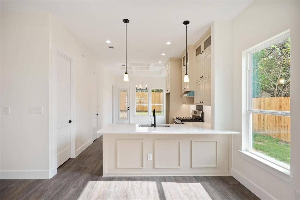 802.5 N Needmore Street, Athens, TX 75751 Kitchen featuring dark wood-type flooring, stainless steel range with gas cooktop, a peninsula, a chandelier, and glass fronted cabinets