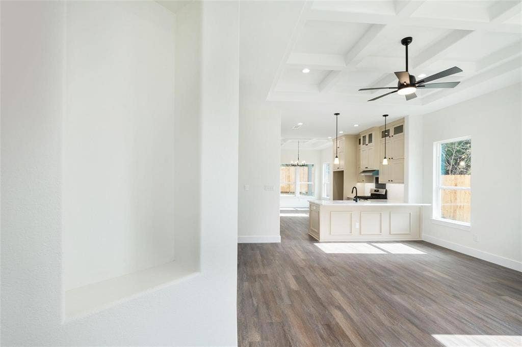 802.5 N Needmore Street, Athens, TX 75751 Unfurnished living room with coffered ceiling, dark wood finished floors, suspended lighting, and a ceiling fan