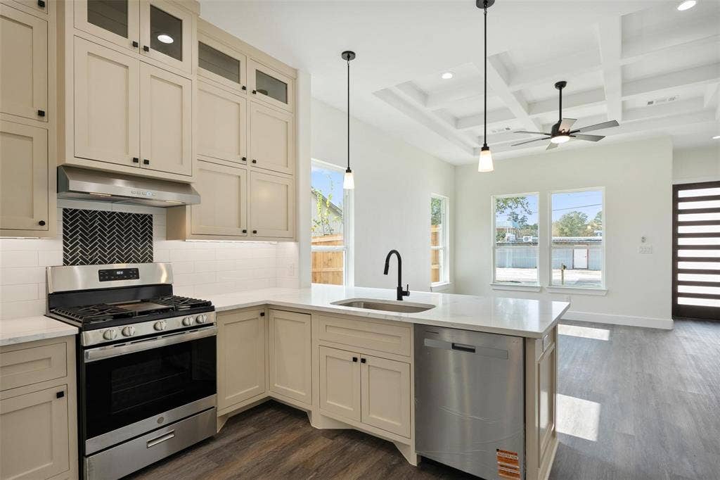 802.5 N Needmore Street, Athens, TX 75751 Kitchen with stainless steel appliances, cream cabinetry, coffered ceiling, backsplash, and dark wood-type flooring