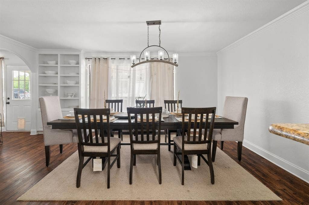 4200 Jennifer Lane, Crowley, TX 76036 Dining space featuring ornamental molding, arched walkways, dark wood-type flooring, and suspended lighting