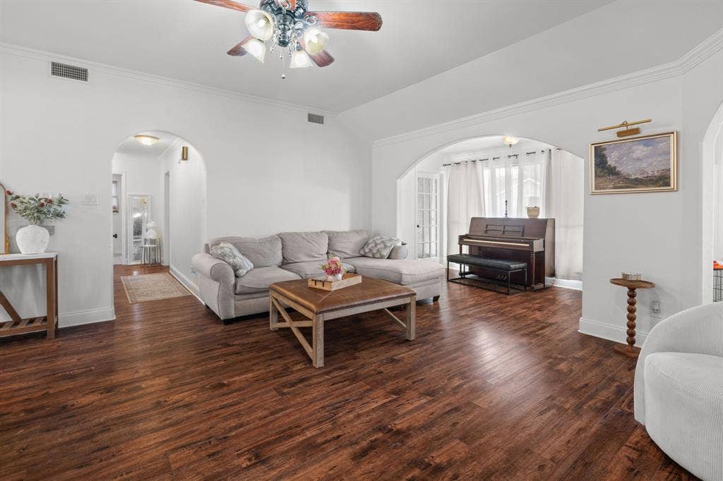 4200 Jennifer Lane, Crowley, TX 76036 Living room featuring vaulted ceiling, arched walkways, a ceiling fan, dark wood-type flooring, and ornamental molding