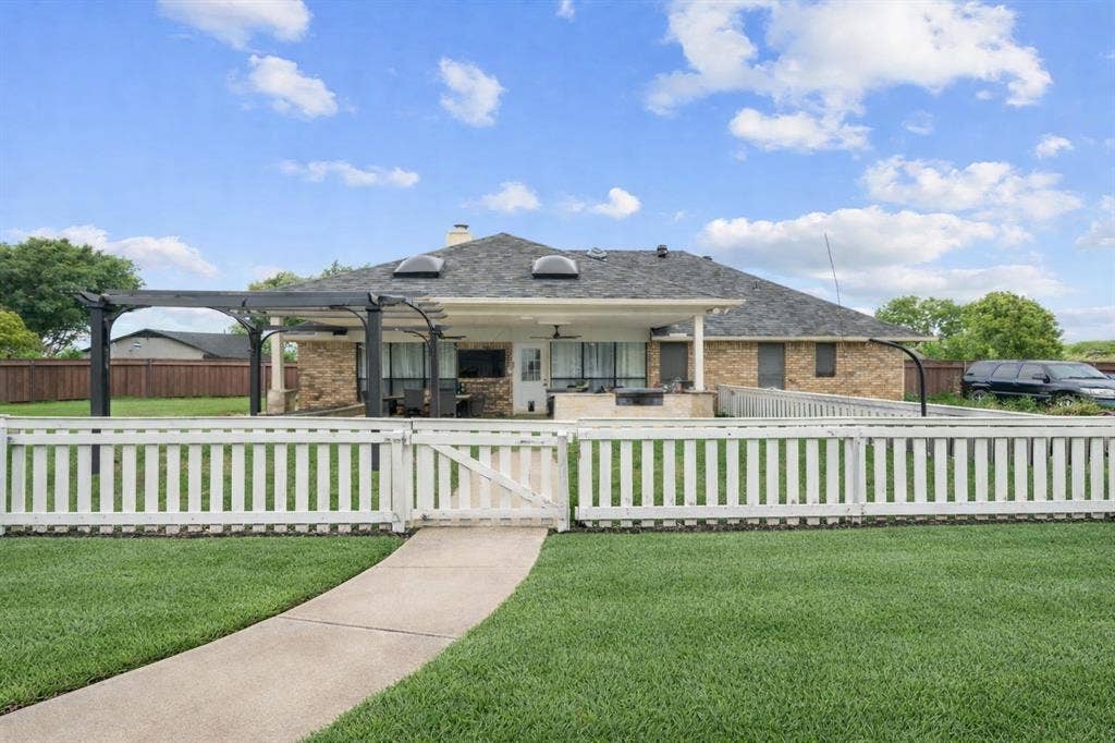 4200 Jennifer Lane, Crowley, TX 76036 View of front of property featuring a gate, a chimney, a fenced front yard, a patio area, and brick siding