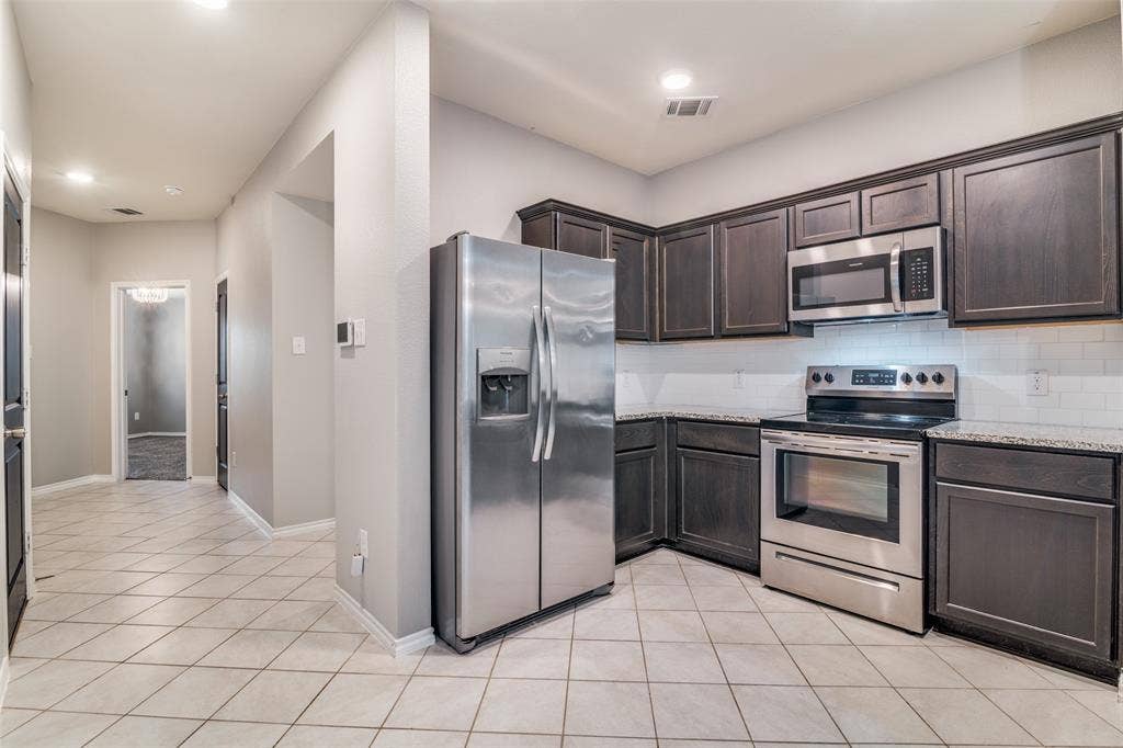 877 Darst Drive, Fate, TX 75189 Kitchen open to living room, refrigerator to convey