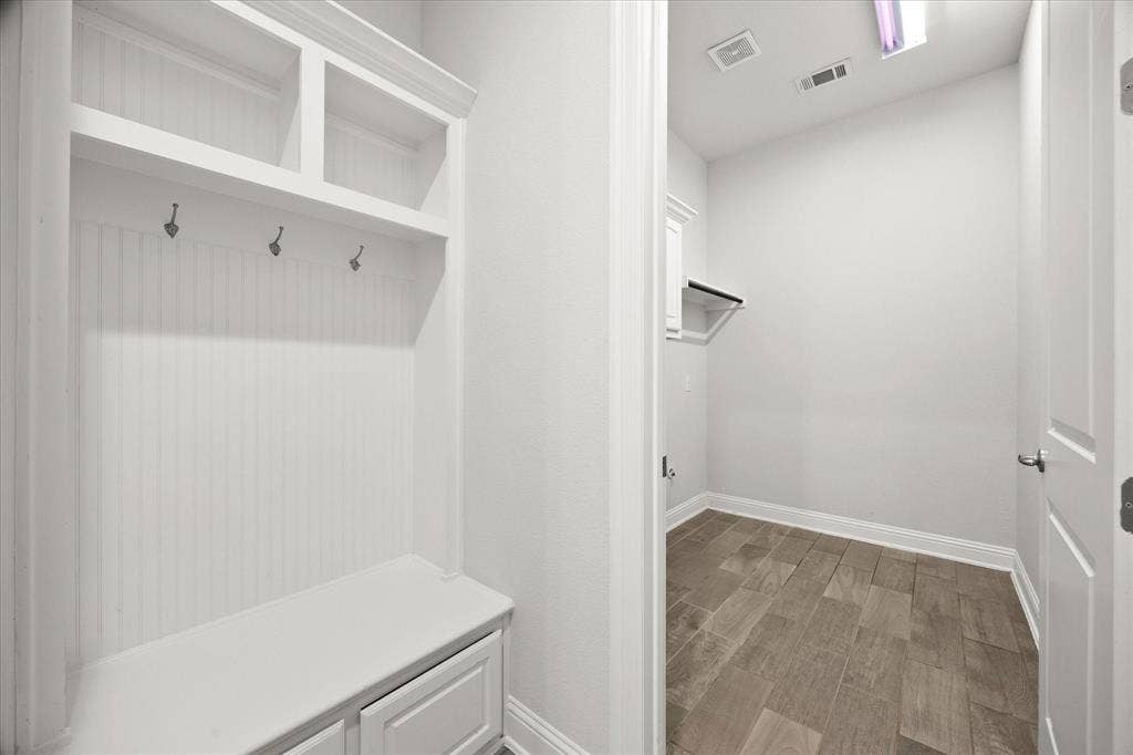 Mudroom featuring a built-in bench with storage, beadboard paneling, and open shelving