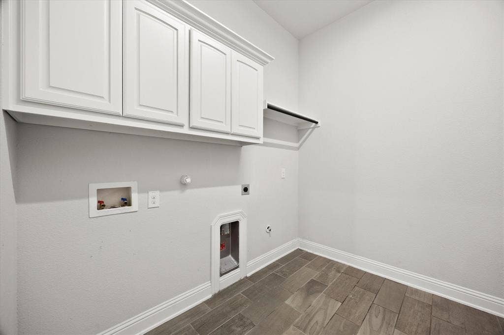 Utility room featuring wood-finish tile flooring, white shaker-style cabinetry, and a black hanging rod