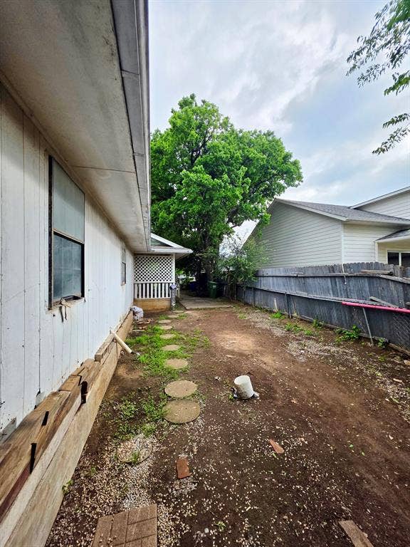 417 W Huffman Street, Krum, TX 76249 Spacious side yard featuring a partial privacy fence and stepping stone pathway