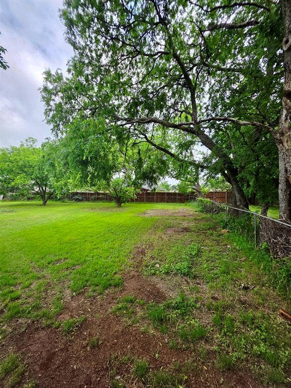 417 W Huffman Street, Krum, TX 76249 Expansive yard space featuring mature trees and a chain-link fence
