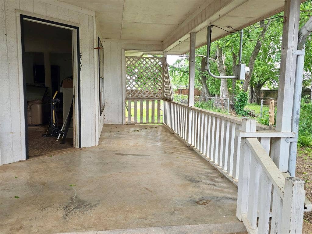 417 W Huffman Street, Krum, TX 76249 Expansive covered porch featuring a concrete slab, painted wood siding, and white wood railing