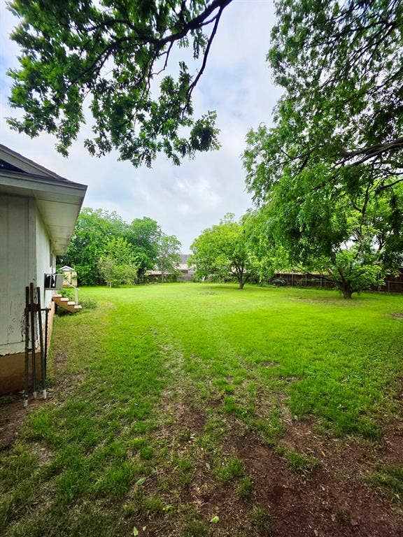 417 W Huffman Street, Krum, TX 76249 Expansive green lawn with mature trees providing natural shading