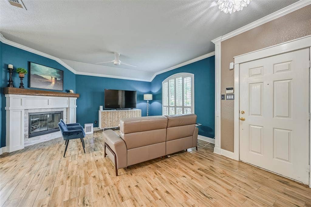 The property features a spacious living area with hardwood flooring and crown molding