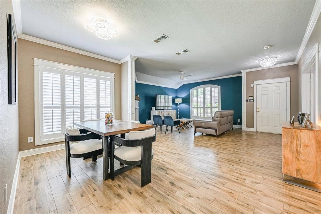 The property features light wood flooring, crown molding, and white interior doors