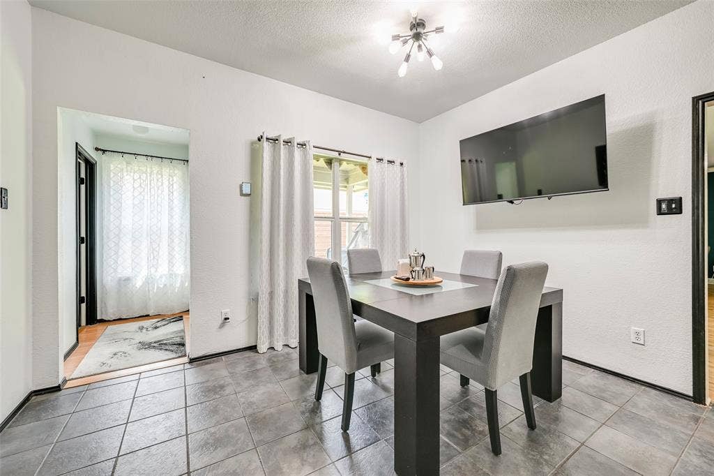 This room features tile flooring, white walls, and a window with white curtains