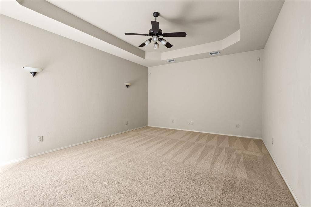 Large media room with tray ceiling and wall sconces. (Note:Media room is over the garage so no concerns with potential noise)