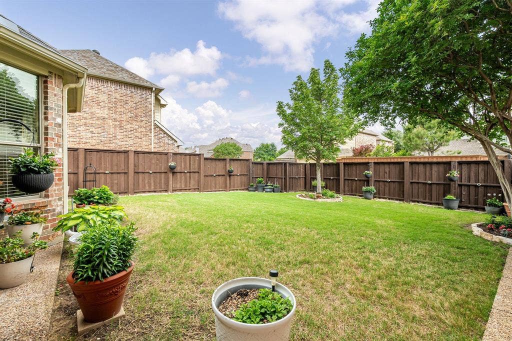 Private backyard with board on board fence and mature landscaping.