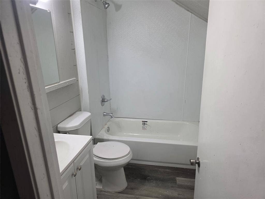 2523 Sanger Avenue, Waco, TX 76707 The bathroom features a white vanity with a rectangular sink, a toilet, and a white bathtub with a shower