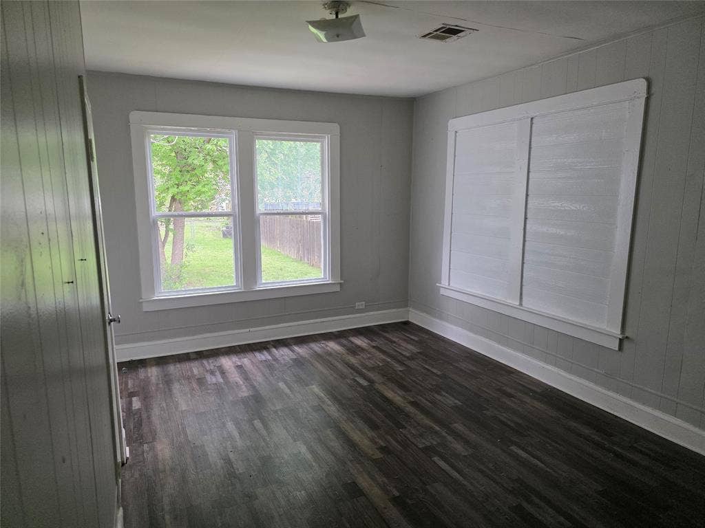 2523 Sanger Avenue, Waco, TX 76707 This room features dark-toned plank flooring, light gray walls, and white trim
