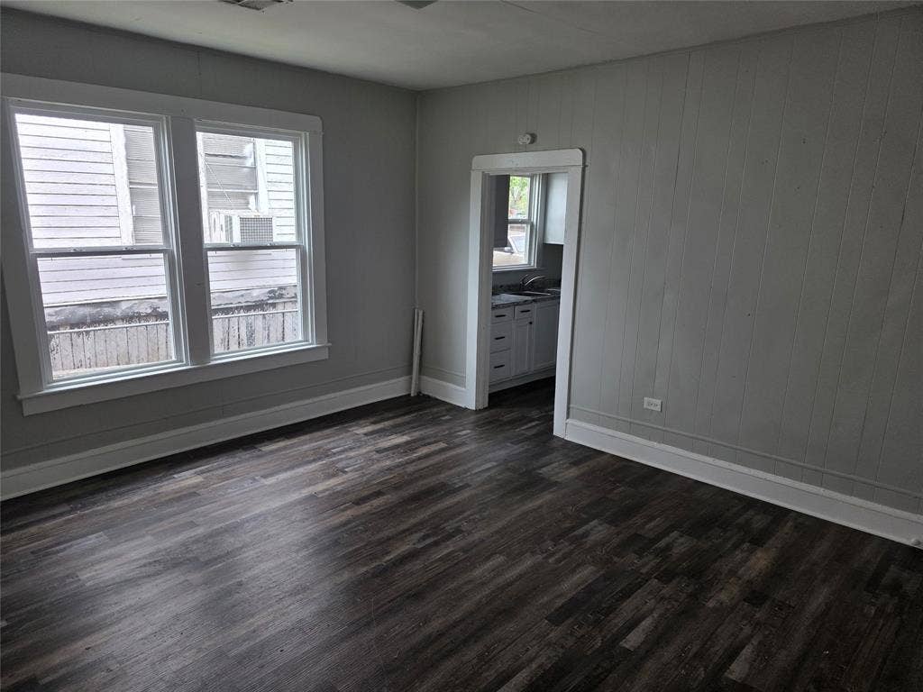 2523 Sanger Avenue, Waco, TX 76707 Living area featuring dark wood-style flooring, light-toned walls, and two windows with white trim